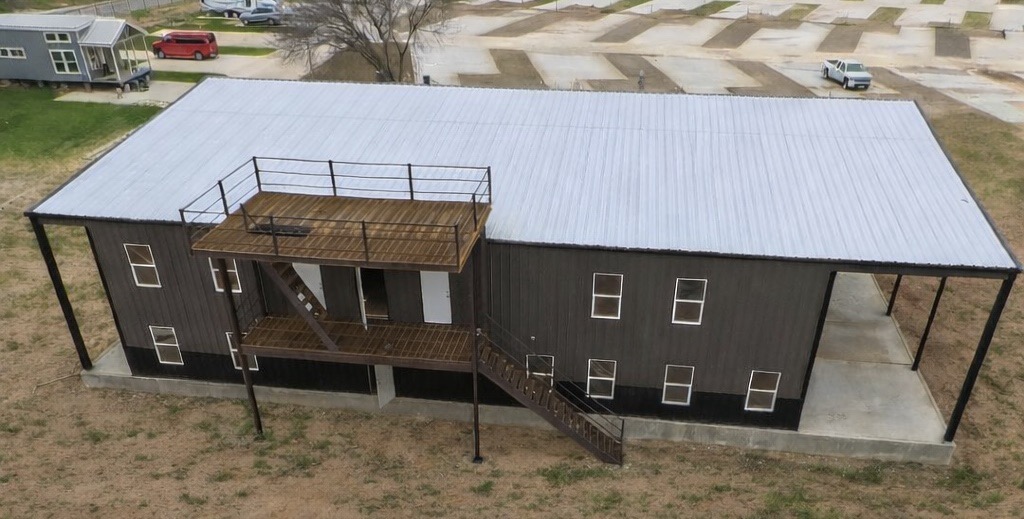 Community facility building with covered porch, washers and dryers, swimming pool, and patio balcony for parties and grilling